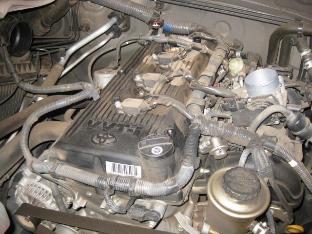 the engine with the intake air connector removed and the wires leading to the ignition coils exposed