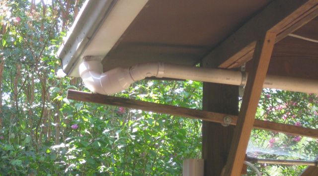 the old connection - a 4" pvc elbow reducing to a 2" pipe and 45 degree elbow held in position by a 8 ft length of 1x1 with the long end rotating on a bolt fulcrum to keep the short end pressing the elbow in position below the gutter outlet. The size reduction guarantees blockages.