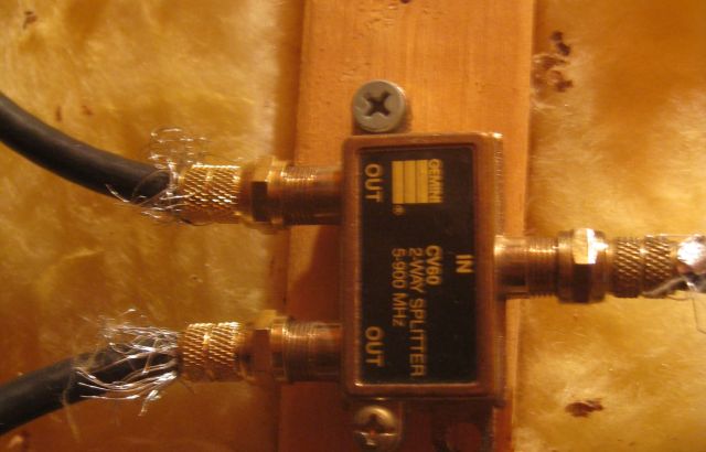 a splitter with antenna signal entering on right & 1 output to upstairs room and 1 output to basement